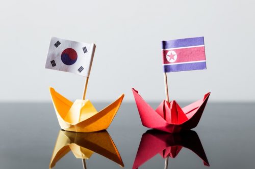 flags of southkorea and northkorea in paper ships